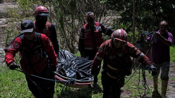 Rescatistas llevan a un hombre muerto hallado en la ribera del río Tuy días después de un derrumbe en la localidad venezolana de Las Tejerías - Sputnik Mundo