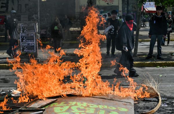 Hace tres años, a mediados de octubre de 2019, comenzaron las protestas en Santiago de Chile por la tarifa media de 30 pesos del metro. Las protestas pronto se convirtieron en disturbios generalizados que se extendieron a otras ciudades del país. Según las cifras oficiales, más de 20 personas murieron en ese momento.En la foto: una barricada en llamas en una calle de Santiago de Chile. - Sputnik Mundo
