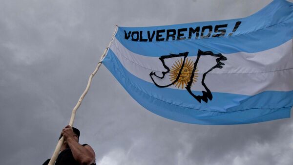 Un hombre sostiene una bandera argentina con un mensaje que dice ¡Volveremos!, durante el aniversario del conflicto de las Islas Malvinas entre el Reino Unido y Argentina - Sputnik Mundo