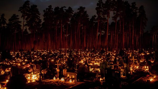 Velas encendidas en las tumbas el Día de Todos los Santos en un cementerio de Vilna, Lituania - Sputnik Mundo