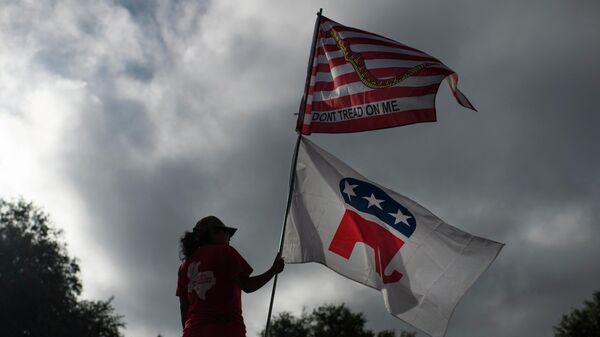 La simpatizante republicana Dolly Schultz sostiene banderas fuera de un centro de votación en el Centro Cívico SSGT Willie de Leon al inicio de la votación en Uvalde, Texas, el 8 de noviembre de 2022.  - Sputnik Mundo