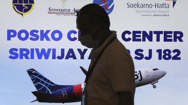 Un miembro del personal pasa por un centro de crisis establecido tras el informe de que un avión de pasajeros de Sriwijaya Air perdió el contacto con los controladores aéreos poco después del despegue, en el Aeropuerto Internacional Soekarno-Hatta en Tangerang, Indonesia, el 9 de enero de 2021 - Sputnik Mundo