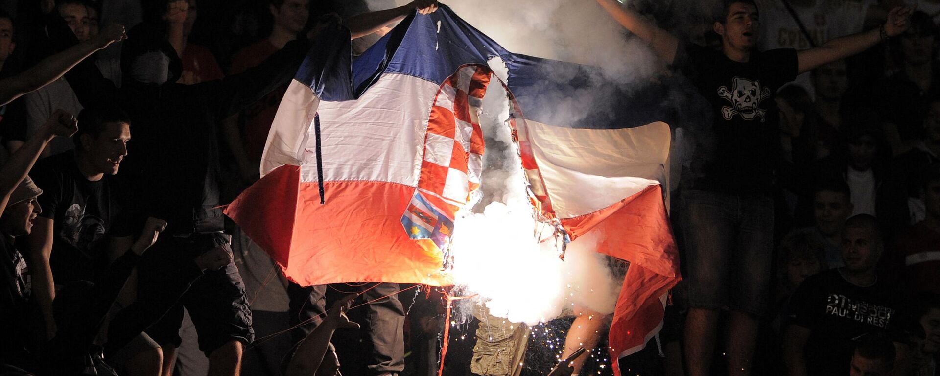 Un grupo de aficionados ultras de Serbia quema una bandera croata durante un partido clasificatorio para el Mundial de Brasil de 2014, en Belgrado - Sputnik Mundo, 1920, 25.11.2022