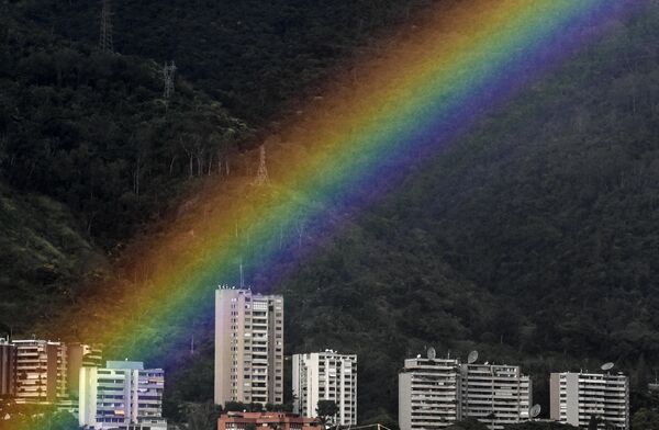 Un arcoíris durante una tormenta eléctrica sobre la ciudad de Caracas y el parque nacional El Ávila, en Venezuela. - Sputnik Mundo