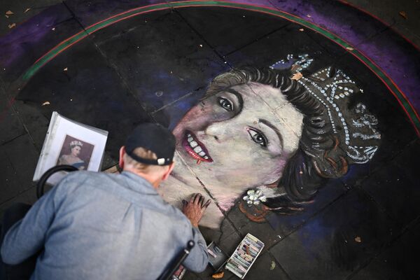 En las losas de la Plaza de Trafalgar un artista callejero dibuja con tiza un retrato de la recientemente fallecida reina Isabel II de Gran Bretaña. - Sputnik Mundo