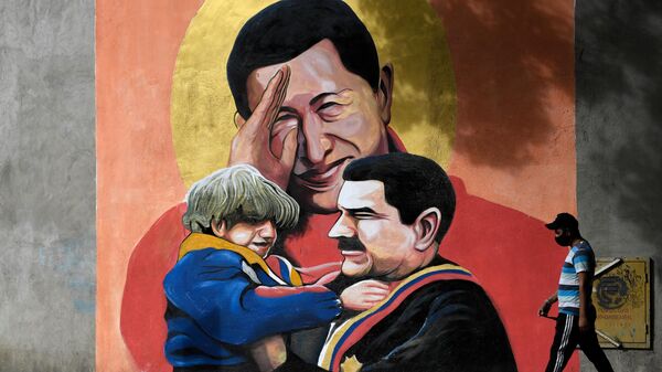 A man walks past a mural depicting Venezuelan late President Hugo Chavez and Venezuelan President Nicolas Maduro in Caracas - Sputnik Mundo