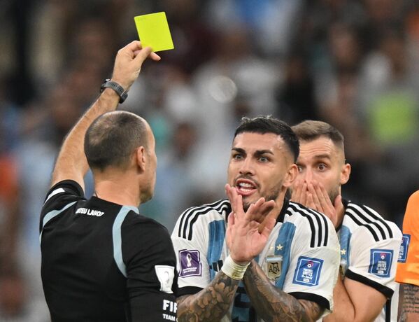 El árbitro Antonio Lahoz muestra la tarjeta amarilla al centrocampista argentino Leandro Daniel Paredes (ctro.) en el partido de cuartos de final entre Argentina y Países Bajos. - Sputnik Mundo