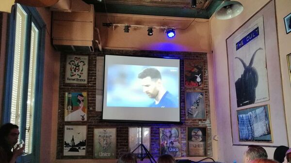 Aficionados argentinos siguen a Messi durante su encuentro contra la selección de Polonia, en fase de grupos, en un bar de Buenos Aires. - Sputnik Mundo