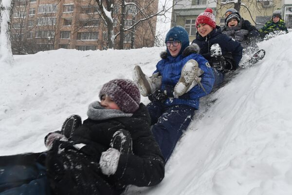 Los niños juegan en el tobogán formado por la nieve en las zonas residenciales de Moscú. - Sputnik Mundo