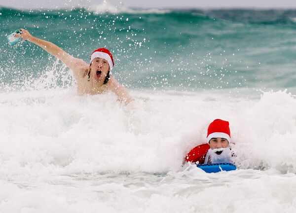 Hombres vestidos de Santa Claus en la playa de Bondi, Sídney (Australia). - Sputnik Mundo