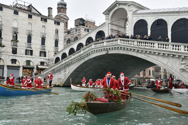 Personas disfrazadas de Santa flotan en góndolas bajo el puente de Rialto en Venecia, Italia. - Sputnik Mundo