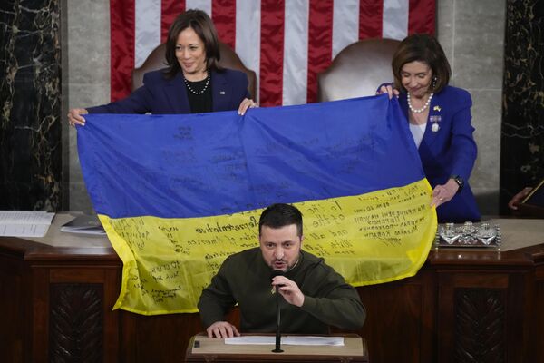 La vicepresidenta estadounidense Kamala Harris y la presidenta de la Cámara de Representantes Nancy Pelosi sostienen la bandera ucraniana firmada por militares ucranianos mientras el presidente ucraniano Volodímir Zelenski se dirige al Congreso. - Sputnik Mundo