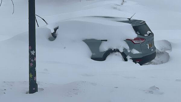 Un coche permanece inmóvil y cubierto de nieve, el 25 de diciembre de 2022, en Buffalo, Nueva York - Sputnik Mundo