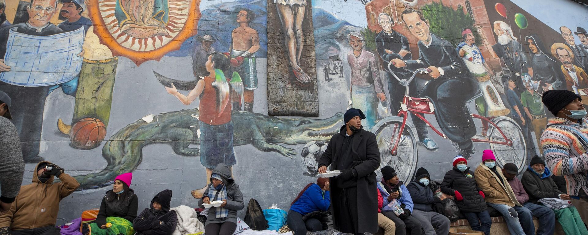 Migrantes comen y esperan ayuda mientras acampan en una calle del centro de El Paso, Texas, el domingo 18 de diciembre de 2022.  - Sputnik Mundo, 1920, 28.01.2023