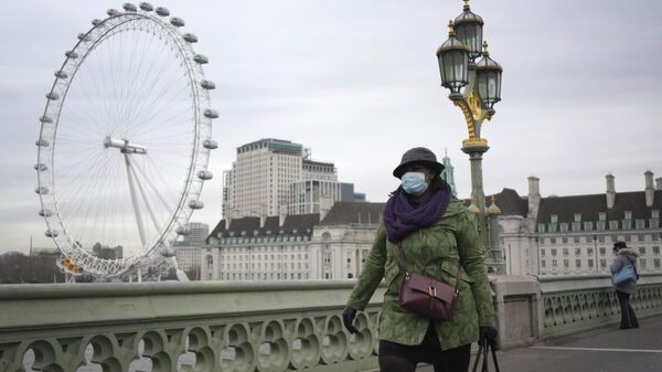 Una mujer camina sobre el puente de Westminster en Londres.  - Sputnik Mundo