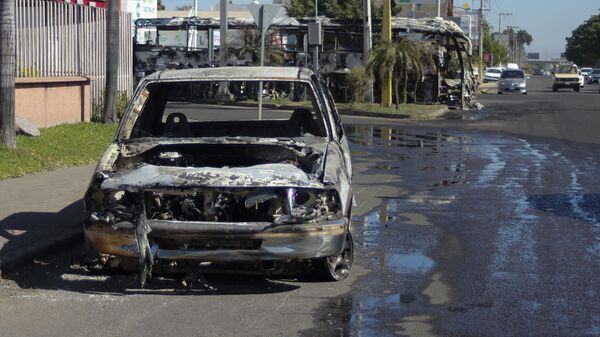 Un coche quemado en Culiacán, Sinaloa, durante los disturbios tras la detención de Ovidio Guzmán - Sputnik Mundo