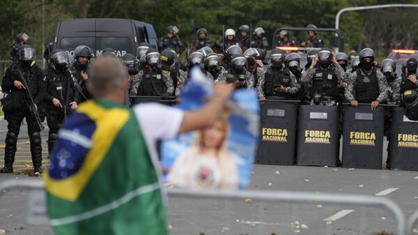 Un manifestante, partidario del expresidente de Brasil Jair Bolsonaro, enfrentado a la policía brasileña - Sputnik Mundo