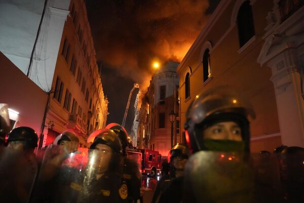 En el centro de la capital, lo policías bloquean la calle que se encuentra frente al edificio en llamas. - Sputnik Mundo