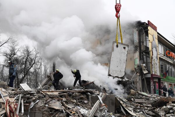 Los rescatistas trabajan en el lugar donde se encontraba un centro comercial en Donetsk, tras ser destruido por los bombardeos de las Fuerzas Armadas ucranianas. - Sputnik Mundo