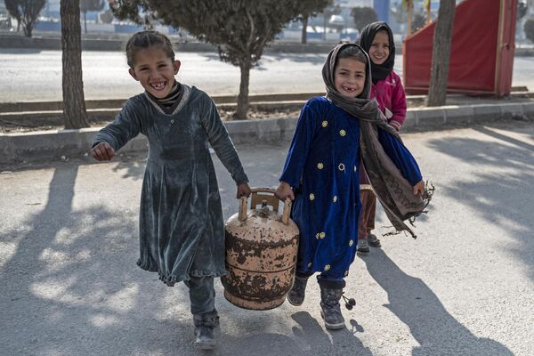 Dos niñas llevan una garrafa de gas por una calle de Kabul, en Afganistán. - Sputnik Mundo