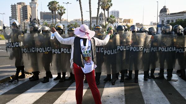 Una mujer enfrenta a la policía en Lima durante una protesta por la renuncia de la presidenta Dina Boluarte. - Sputnik Mundo