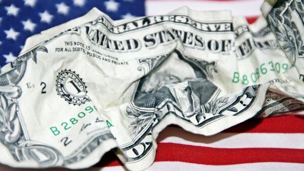 Un dólar arrugado sobre la bandera de EEUU (Imagen referencial) - Sputnik Mundo