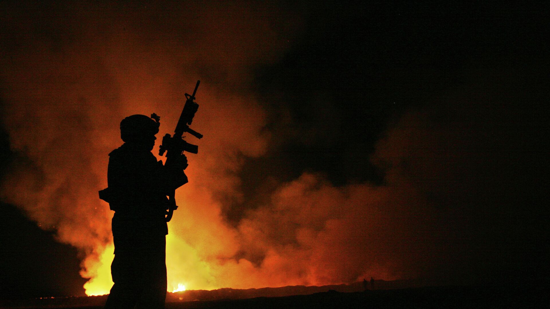 EL sargento Robert B Brown vigila a los bomberos civiles en el lugar del incendio mientras el humo y las llamas se elevan hacia el cielo nocturno a sus espaldasa, 25 de mayo de 2007  - Sputnik Mundo, 1920, 05.02.2023