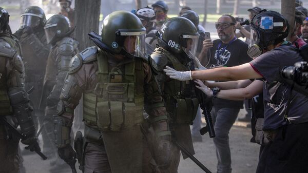 Policíasse enfrentan a manifestantes durante una protesta contra el gobierno del presidente chileno Sebastián Piñera en Santiago, el 27 de diciembre de 2019 - Sputnik Mundo