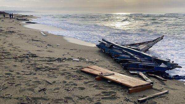 Parte de los restos de una barca naufragada en una playa cercana a Cutro, Italia - Sputnik Mundo