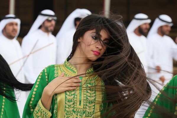 Una mujer baila una danza tradicional en un festival de camellos en las afueras de Abu Dabi, EAU. Una mujer baila una danza tradicional en un festival de camellos en las afueras de Abu Dabi, EAU. - Sputnik Mundo