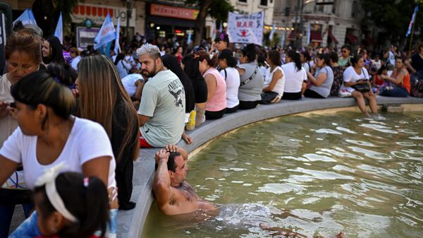 Жители Буэнос-Айреса охлаждаютс в фонтане и возле него в период аномальной жары в Аргентине - Sputnik Mundo