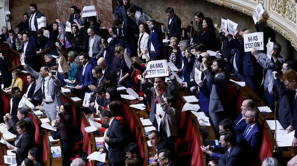 Legisladores de extrema izquierda reaccionan mientras sostienen un papel en el que se lee: 64 años. Es no en la Asamblea Nacional de París - Sputnik Mundo
