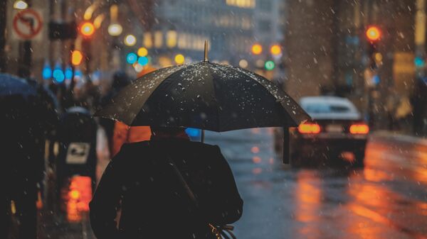 Una persona con paraguas bajo la lluvia. Imagen referencial  - Sputnik Mundo