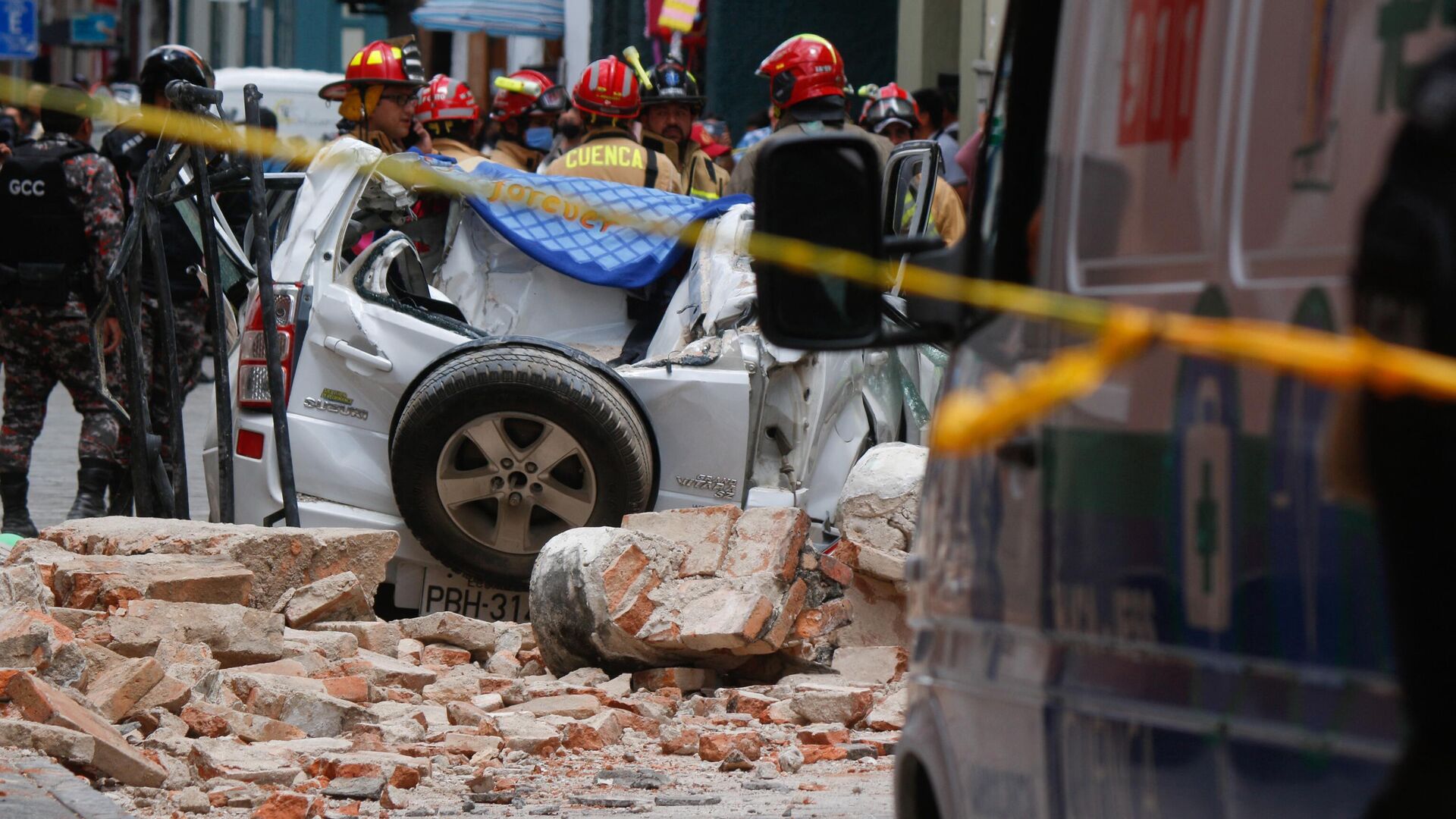 Vista de un auto destruido tras la caída de una terraza de un edificio en el centro histórico de Cuenca, que dejó un muerto y una persona herida, tras un terremoto el 18 de marzo de 2023.  - Sputnik Mundo, 1920, 18.03.2023