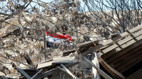 La bandera siria, a través de los escombros tras un ataque israelí - Sputnik Mundo