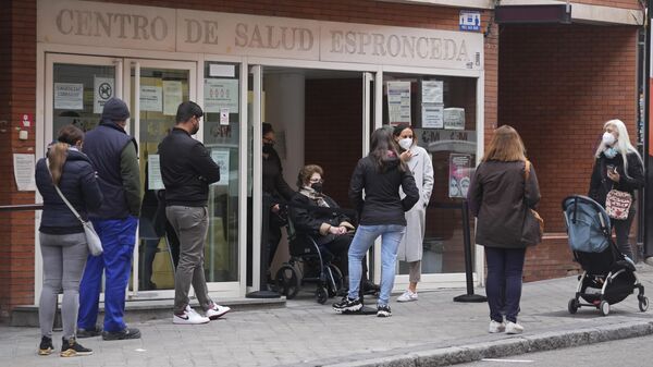 Varias personas hacen cola frente a un centro de salud local en Madrid, España - Sputnik Mundo