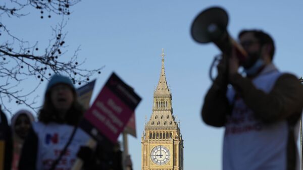 Un manifestante con un megáfono grita consignas frente al Big Ben mientras las enfermeras del cercano hospital St. Thomas protestan en Londres, el 6 de febrero de 2023 - Sputnik Mundo