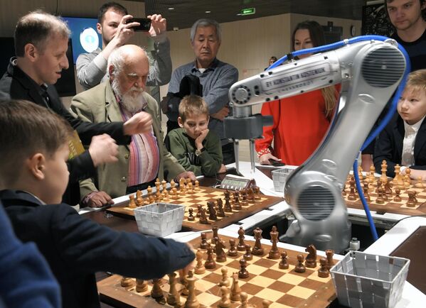 Los robots ya realizan algunas tareas mucho mejor que las personas. En la foto: el robot ajedrecista juega al ajedrez con tres visitantes en el campeonato mundial de ajedrez en el ritmo rápido y blitz del año 2019 en Moscú. - Sputnik Mundo