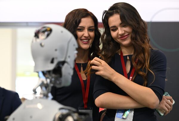 Unas visitantes examinan el robot-promotor de servicios Alexa en el Foro Económico Oriental del año 2022 en Vladivostok - Sputnik Mundo