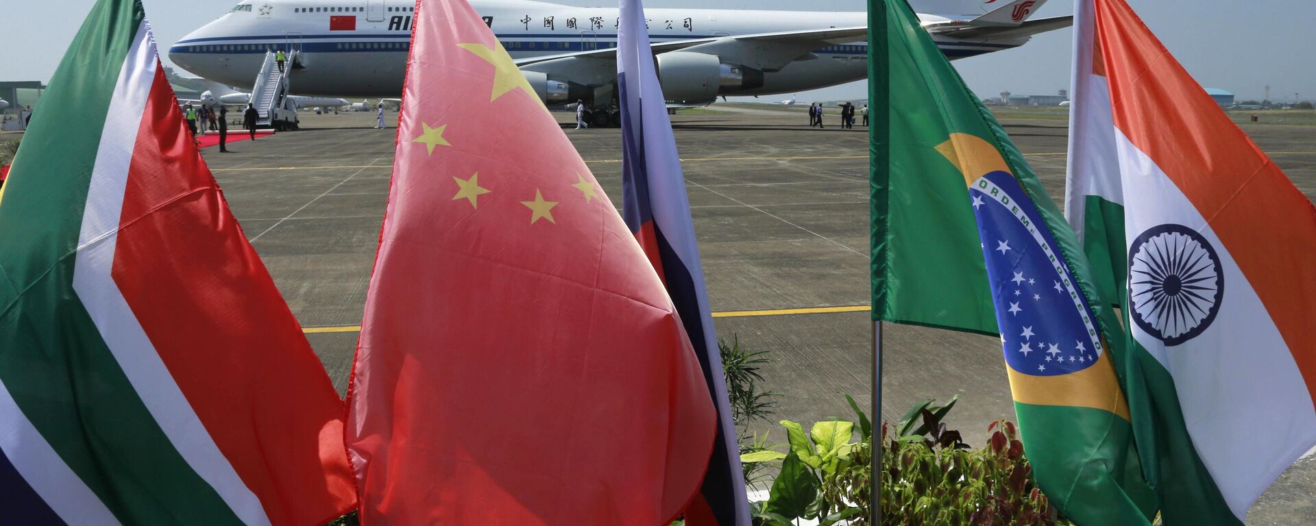 Banderas de los cinco países que componen el BRICS frente a la aeronave de Air China, en la cual el presidente chino Xi Jinping llego para participar de la cumbre de la organización en Goa, Índia, el 15 de octubre de 2016 - Sputnik Mundo, 1920, 02.06.2023