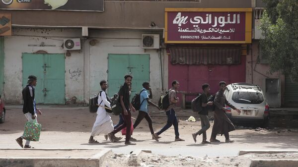 La gente pasa frente a tiendas cerradas en Jartum, Sudán, el 17 de abril de 2023.  - Sputnik Mundo
