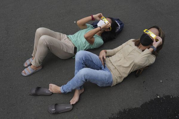 Los eclipses de ese tipo son bastante raros y se producen aproximadamente una vez cada década.En la foto: la gente se tumba en el suelo mientras usa gafas protectoras para ver el eclipse solar en Yakarta, Indonesia. Los eclipses de ese tipo son bastante raros y se producen aproximadamente una vez cada década.En la foto: la gente se tumba en el suelo mientras usa gafas protectoras para ver el eclipse solar en Yakarta, Indonesia. - Sputnik Mundo