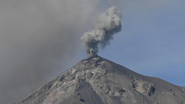 Una columna de ceniza y humo se eleva desde el Volcán de Fuego, visto desde Alotenango, un municipio en el departamento de Sacatepéquez, a 65 kilómetros al suroeste de Ciudad de Guatemala el 11 de diciembre de 2022.  - Sputnik Mundo