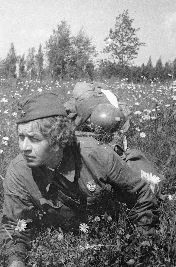 La enfermera Elena Kovalchuk arrastra a un soldado herido por el campo de batalla, junio de 1942. - Sputnik Mundo