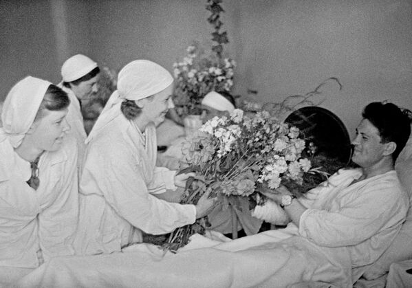 Enfermeras entregan flores a un soldado en un hospital de Moscú, junio de 1941. - Sputnik Mundo