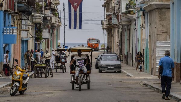 Un hombre monta en un bicitaxi por las calles de La Habana, Cuba, lunes 26 de julio de 2021.  - Sputnik Mundo