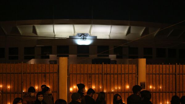 Varias personas reunidas afuera del Estadio Nacional de Chile para prender veladoras en honor a las víctimas de tortura y detención de la dictadura militar de Augusto Pinochet (1973-1990). - Sputnik Mundo
