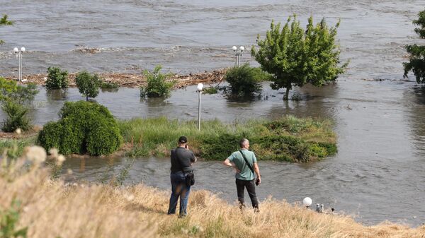 Residentes locales observan una zona parcialmente inundada de Jérson el 6 de junio de 2023, tras los daños sufridos en la presa de la central hidroeléctrica de Kajovka.   - Sputnik Mundo
