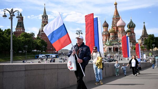 Мужчина с российским национальным флагом у Кремля в центре Москвы - Sputnik Mundo