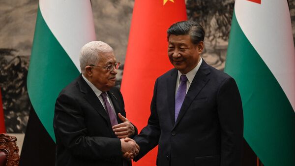 Xi Jinping, el presidente chino, y su homólogo palestino, Mahmud Abás, estrechan las manos durante una reunión, el 14 de junio de 2023 - Sputnik Mundo